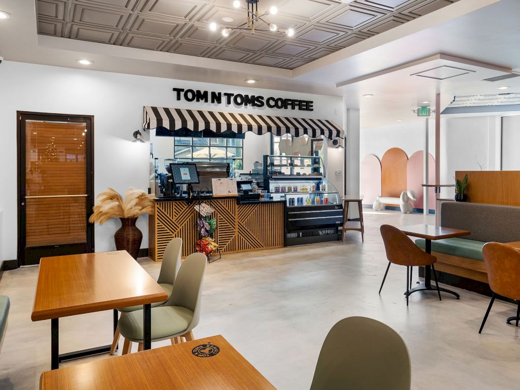 A modern coffee shop with a counter, tables, and chairs