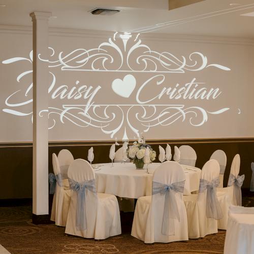 The image shows an elegantly decorated wedding venue with the names "Daisy ♥ Cristian" projected on the wall.