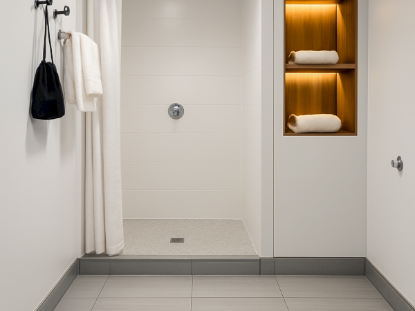 Modern bathroom with a shower, white curtain, towel shelf, and light gray floor tiles, creating a clean and minimalist appearance.