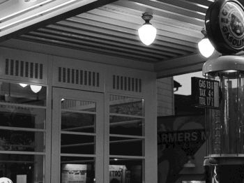 The image shows a vintage-style gas station with the sign "GILMORE" and retro decor elements like a classic pump.